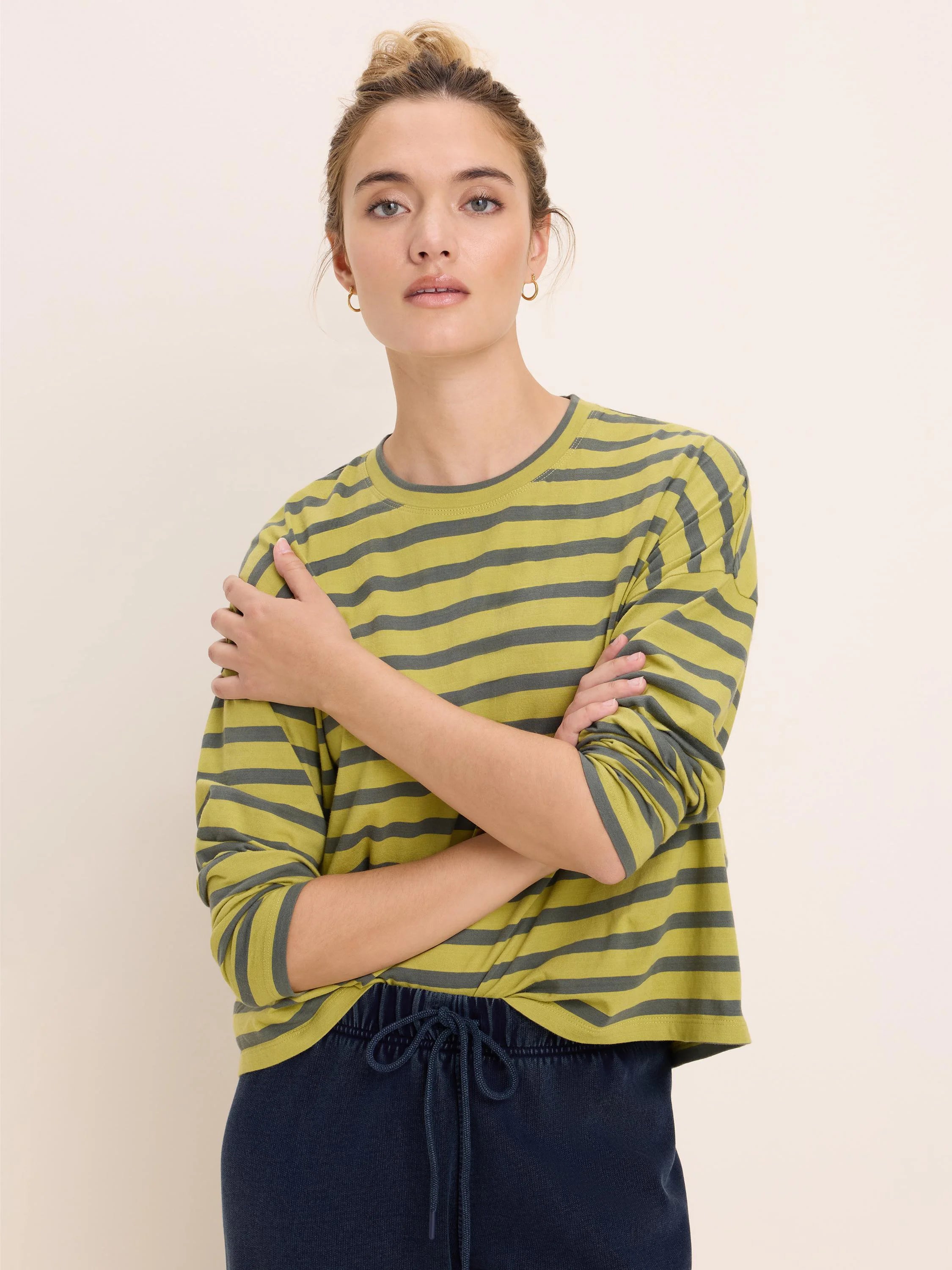 Relaxed fit, long-sleeve, crew neck tee with horizontal greenish-yellow and dark gray stripes.