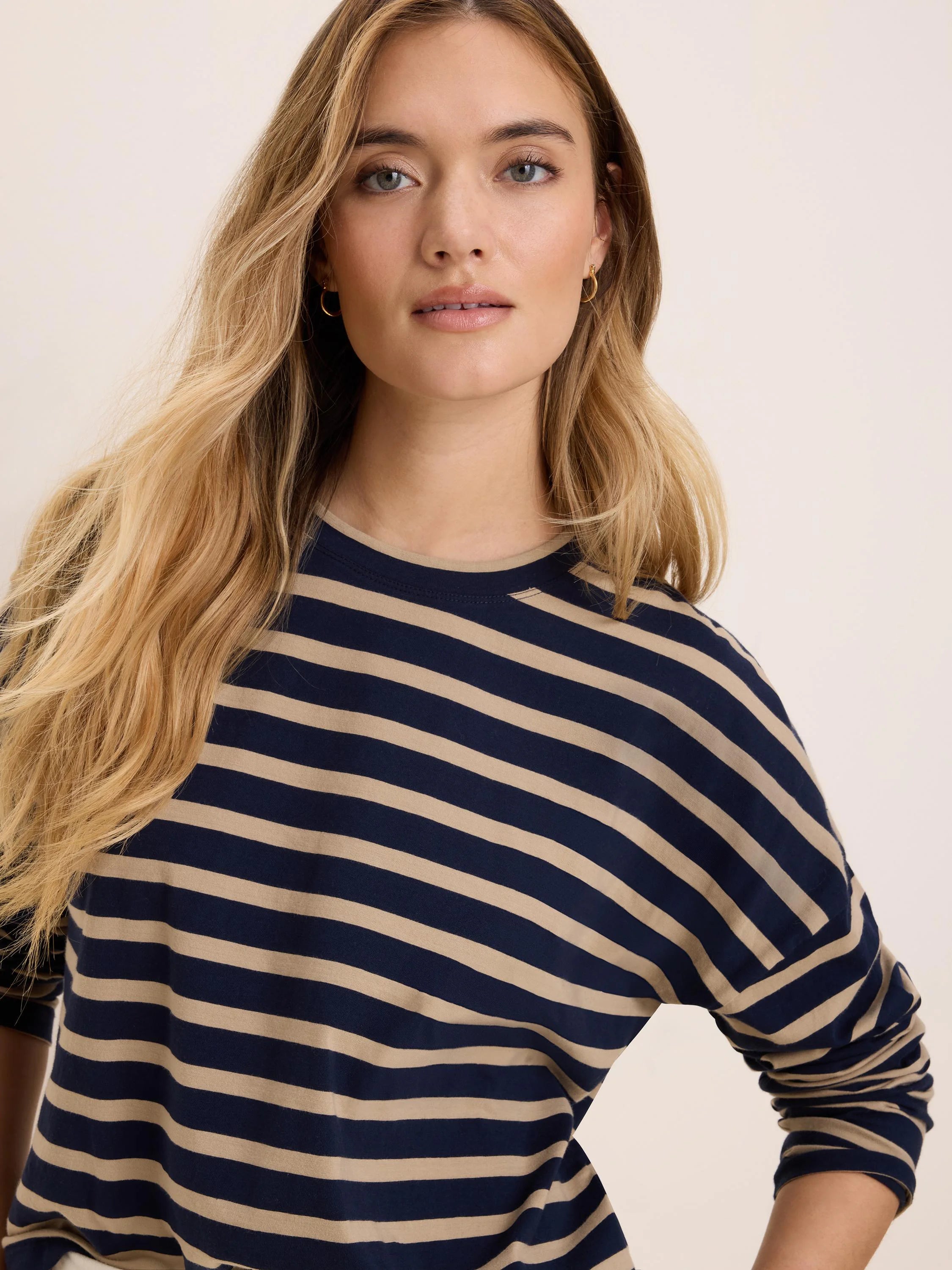 Navy and light beige horizontal striped long-sleeve crew neck tee.