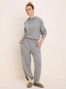 Light grey knit hoodie with a hood, raglan sleeves, ribbed cuffs and hem. Worn with matching knit pants.
