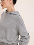Heather grey knit hoodie with raglan sleeves and ribbed cuffs.