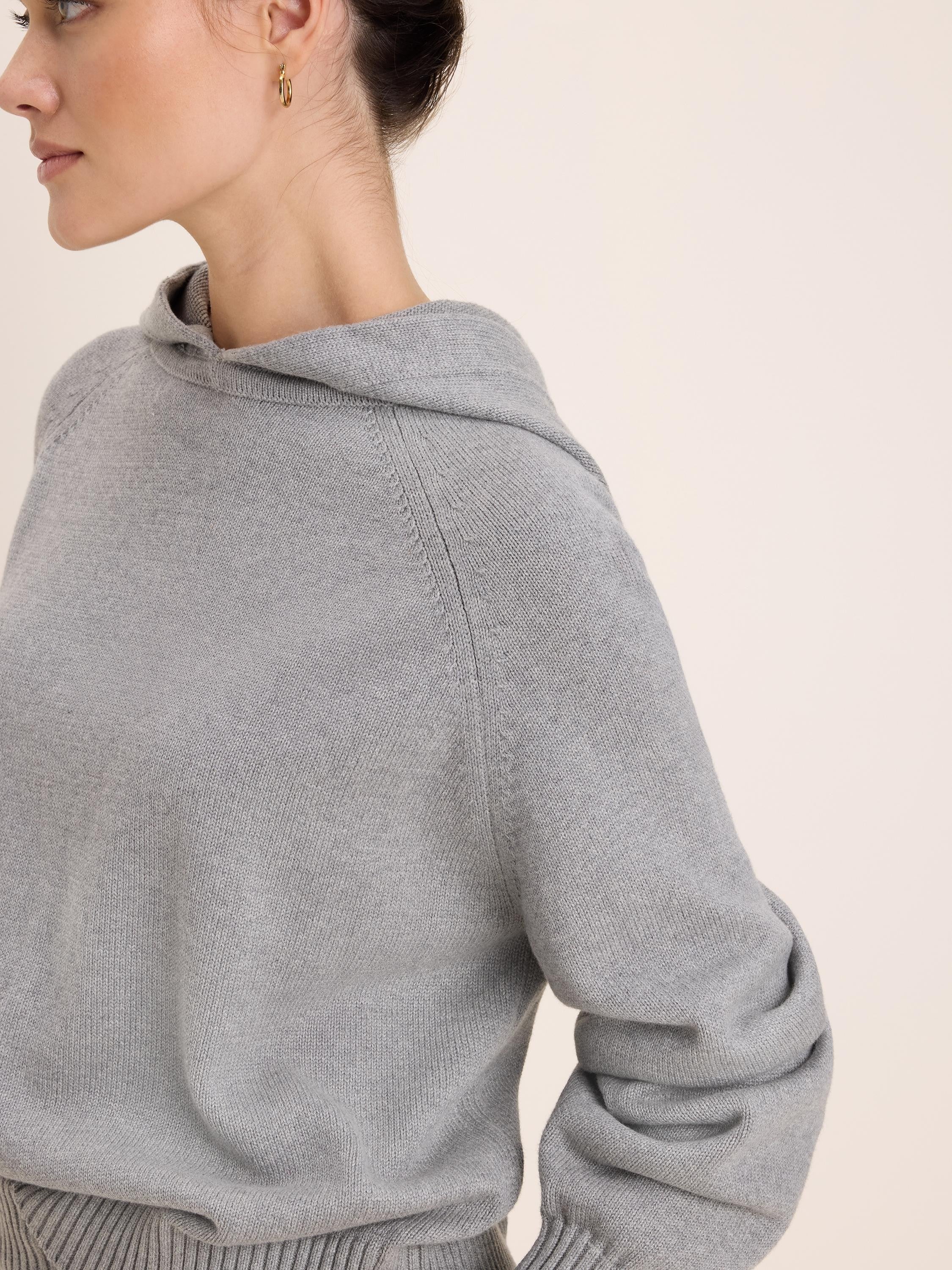 Heather grey knit hoodie with raglan sleeves and ribbed cuffs.