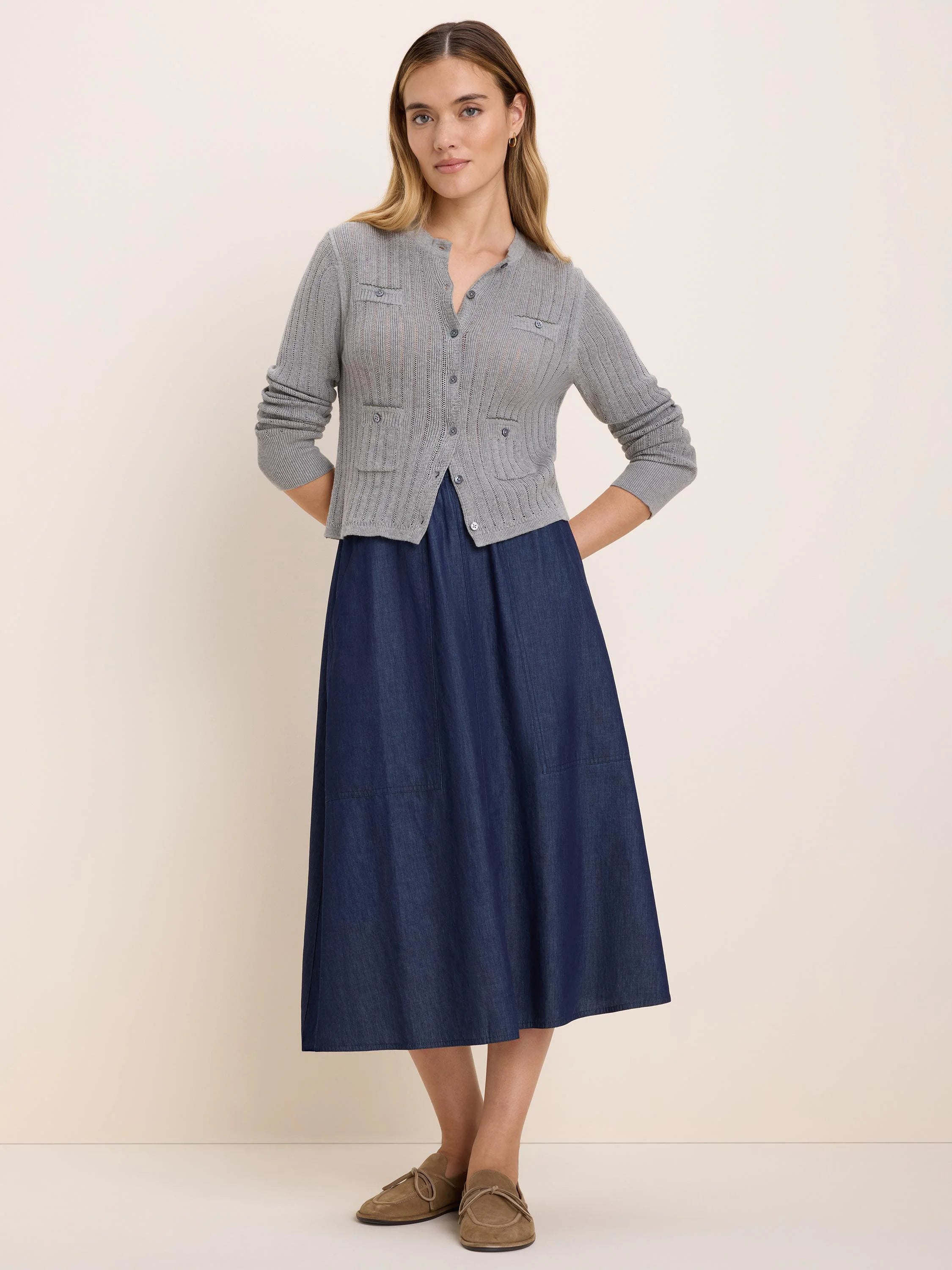 Grey pointelle cardigan with button-front closure and four front patch pockets.