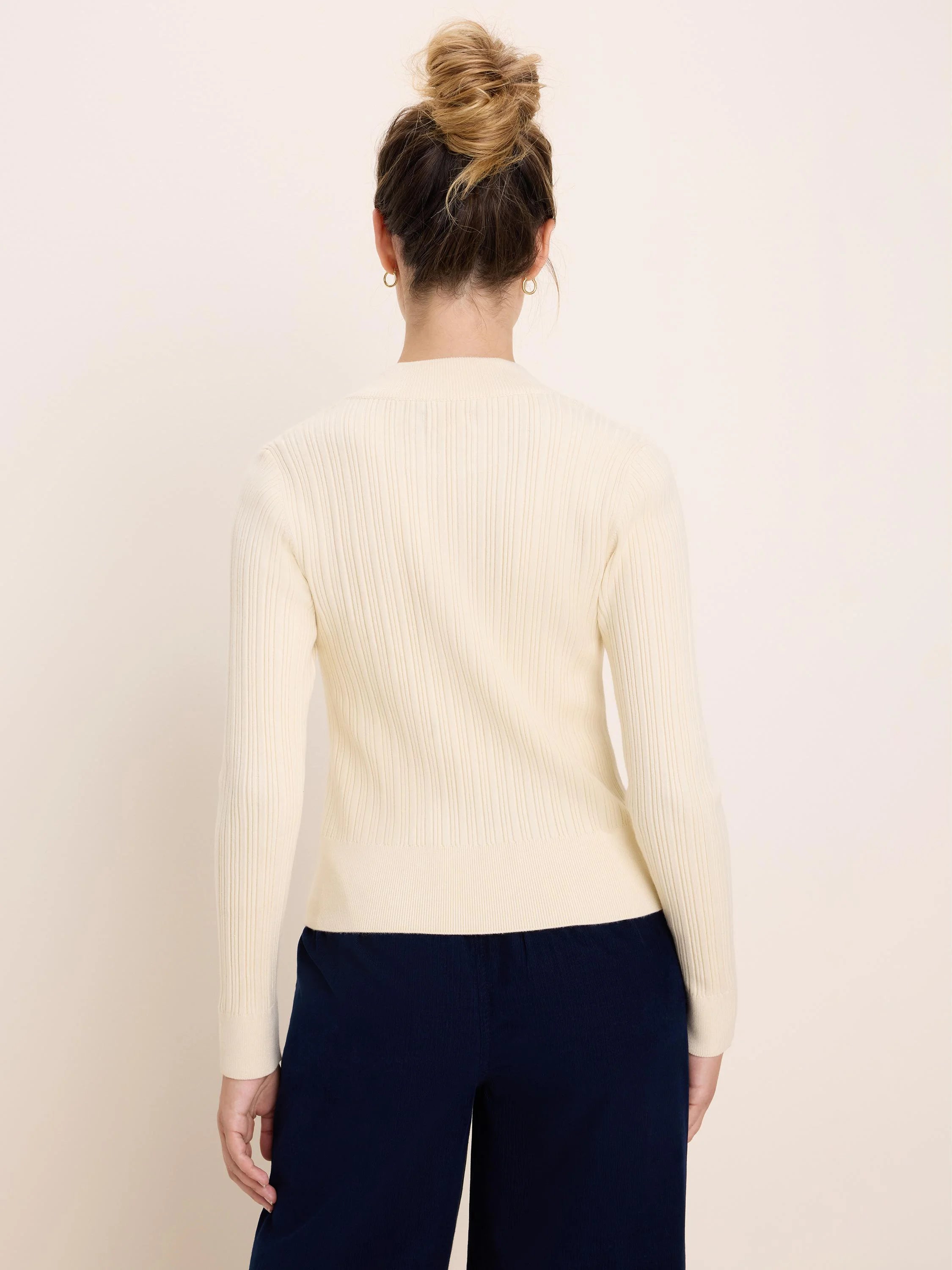 Cream long-sleeve ribbed sweater, back view on model.