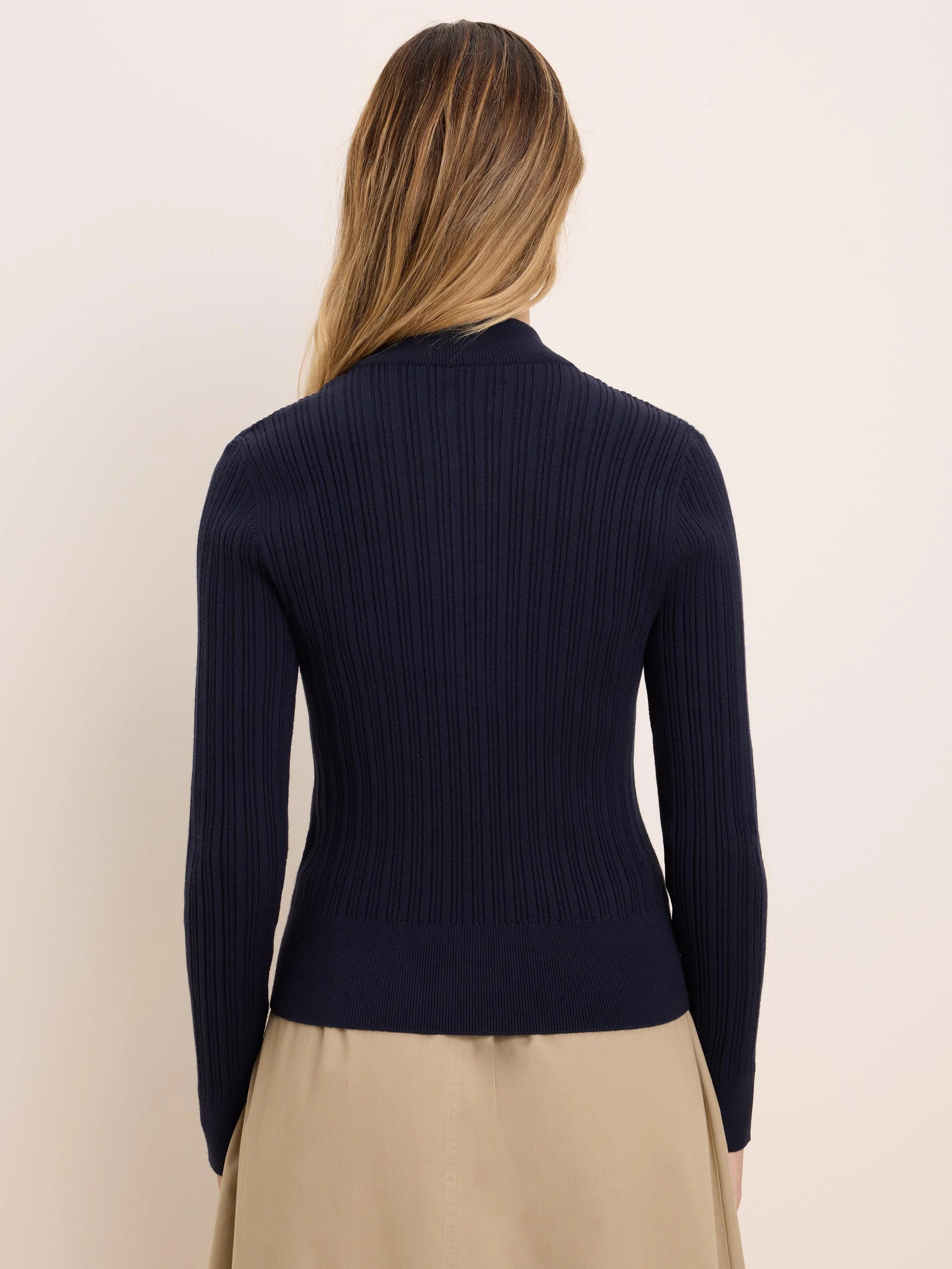 Navy blue, long-sleeved ribbed sweater with a mock neck, shown from the back.