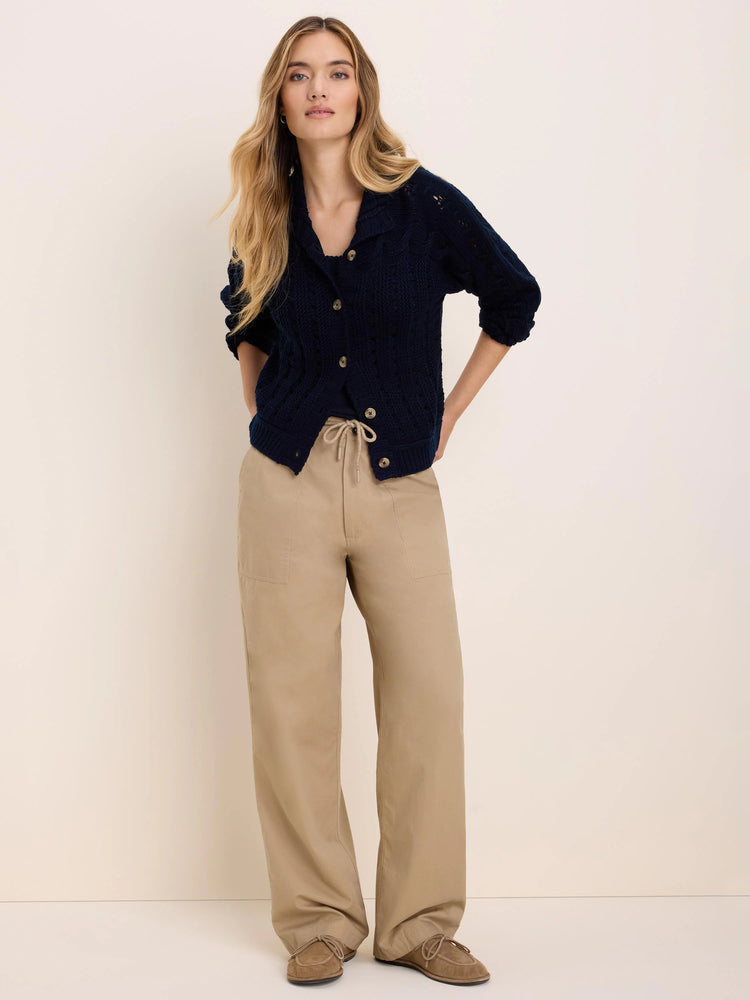Navy cable knit cardigan with a collared neckline, light brown buttons, and 3/4 sleeves.