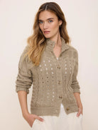 Light brown cable knit cardigan with openwork details, front buttons, and a ribbed stand-up collar.