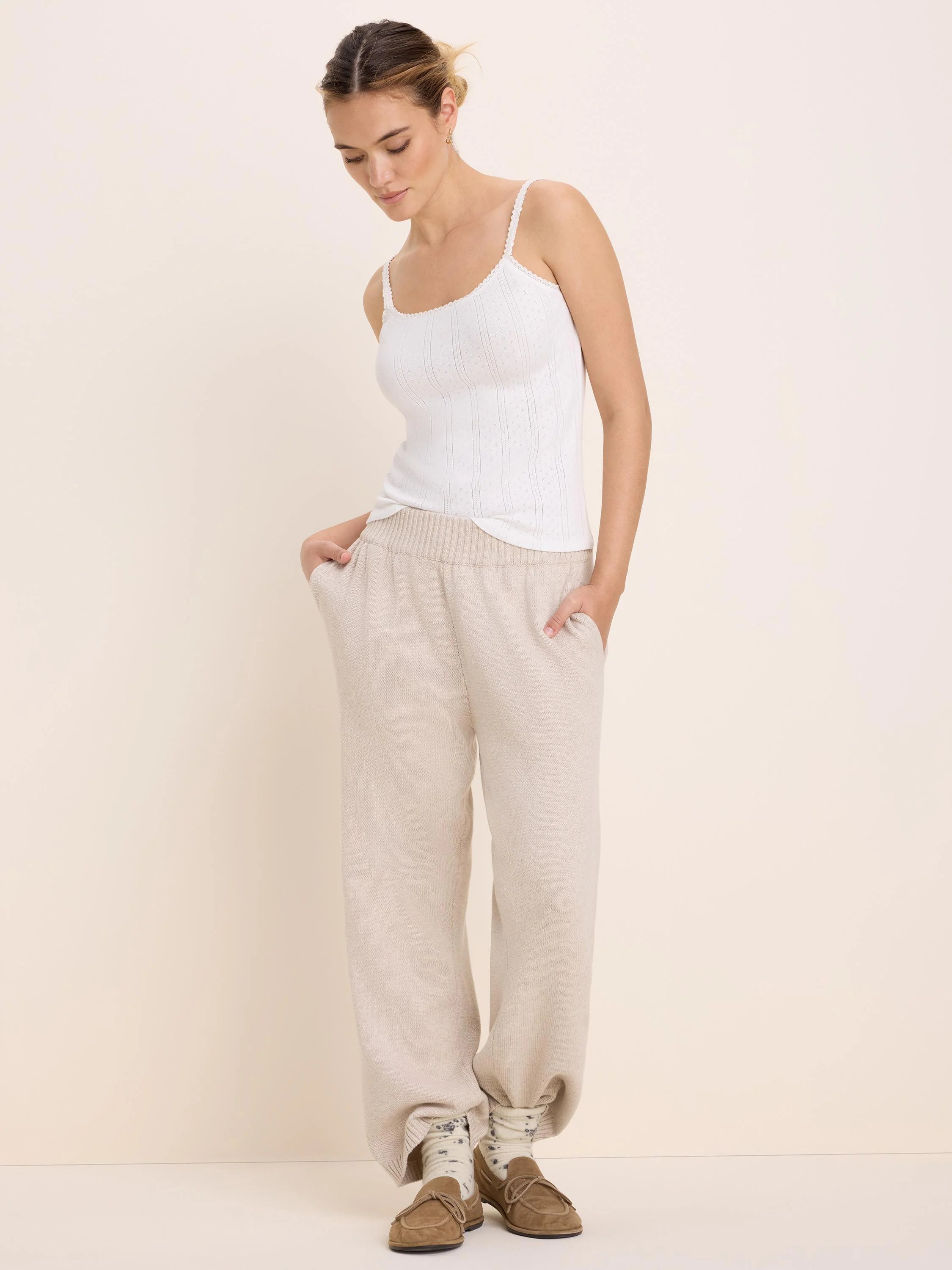 Light beige, relaxed knit sweater pants with a ribbed waist and side pockets.