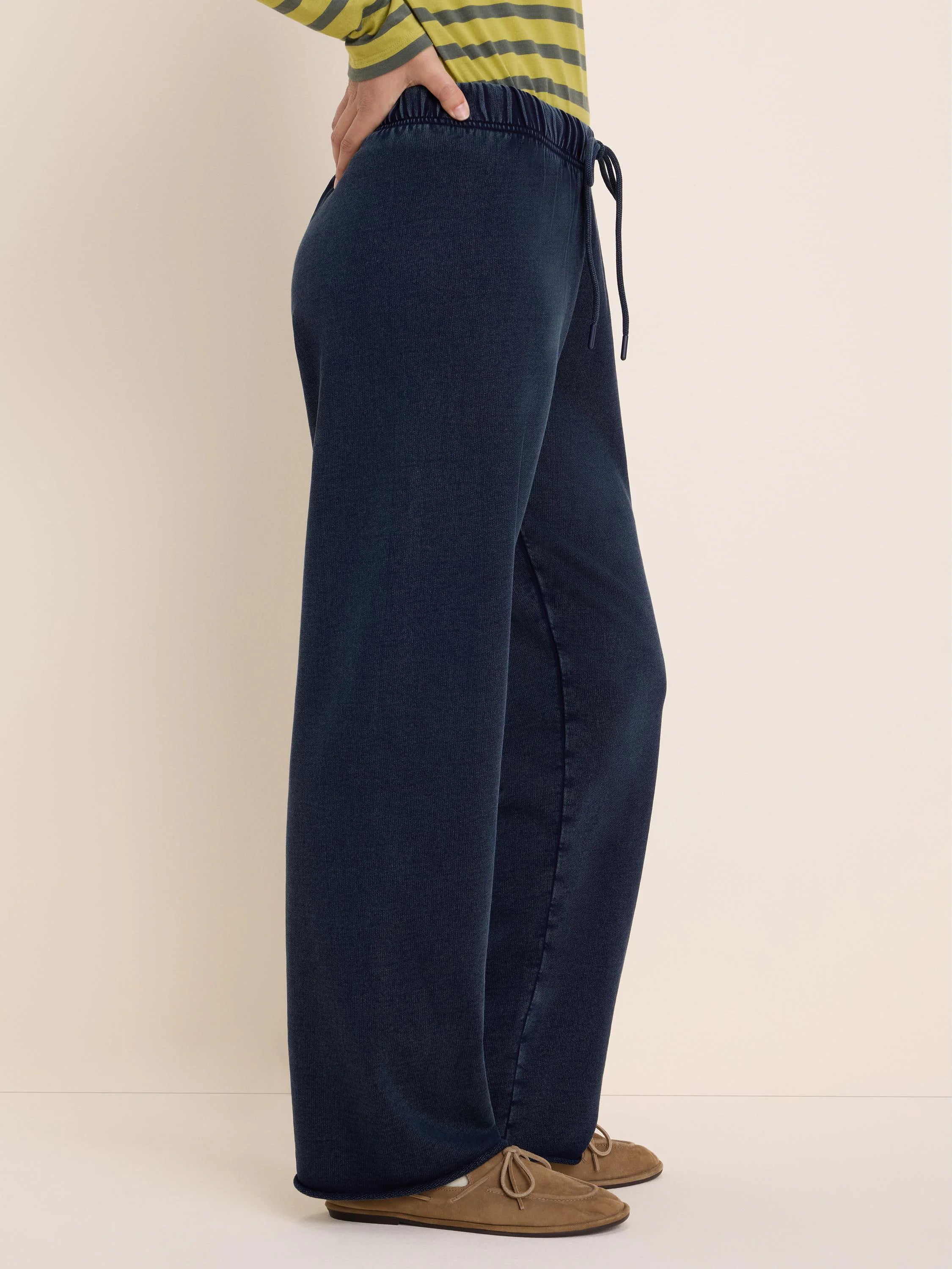 Dark navy wide-leg pants with elastic drawstring waist, showing subtle terry texture. Model shown from side.