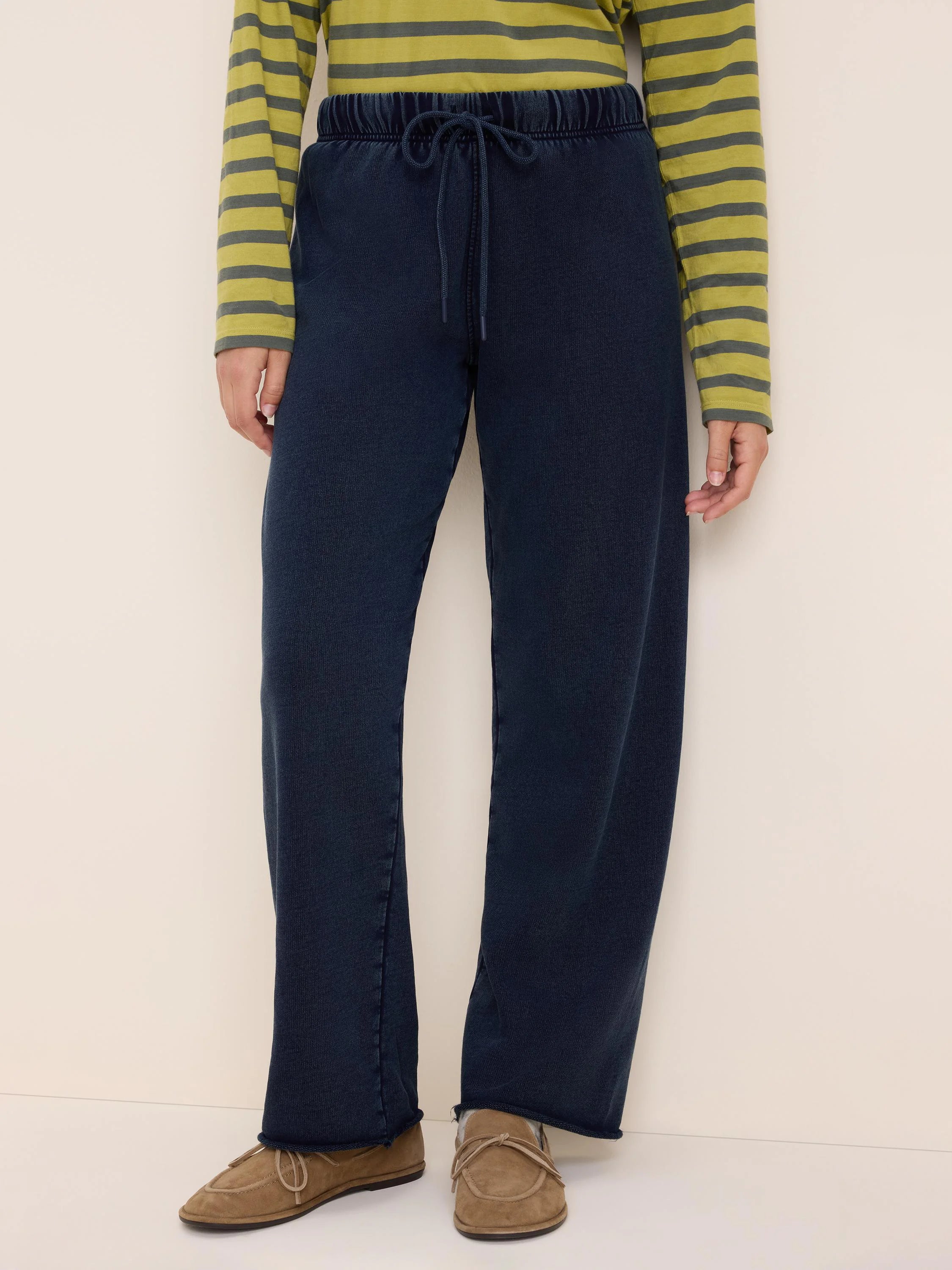 Dark blue wide-leg cotton terry pants with an elastic drawstring waist and raw hem.