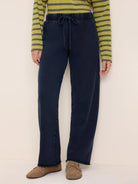 Dark blue wide-leg cotton terry pants with an elastic drawstring waist and raw hem.