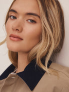 Tan twill jacket with a navy cord collar.