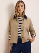 Tan twill jacket with dark blue cord collar, button front, and patch pockets.