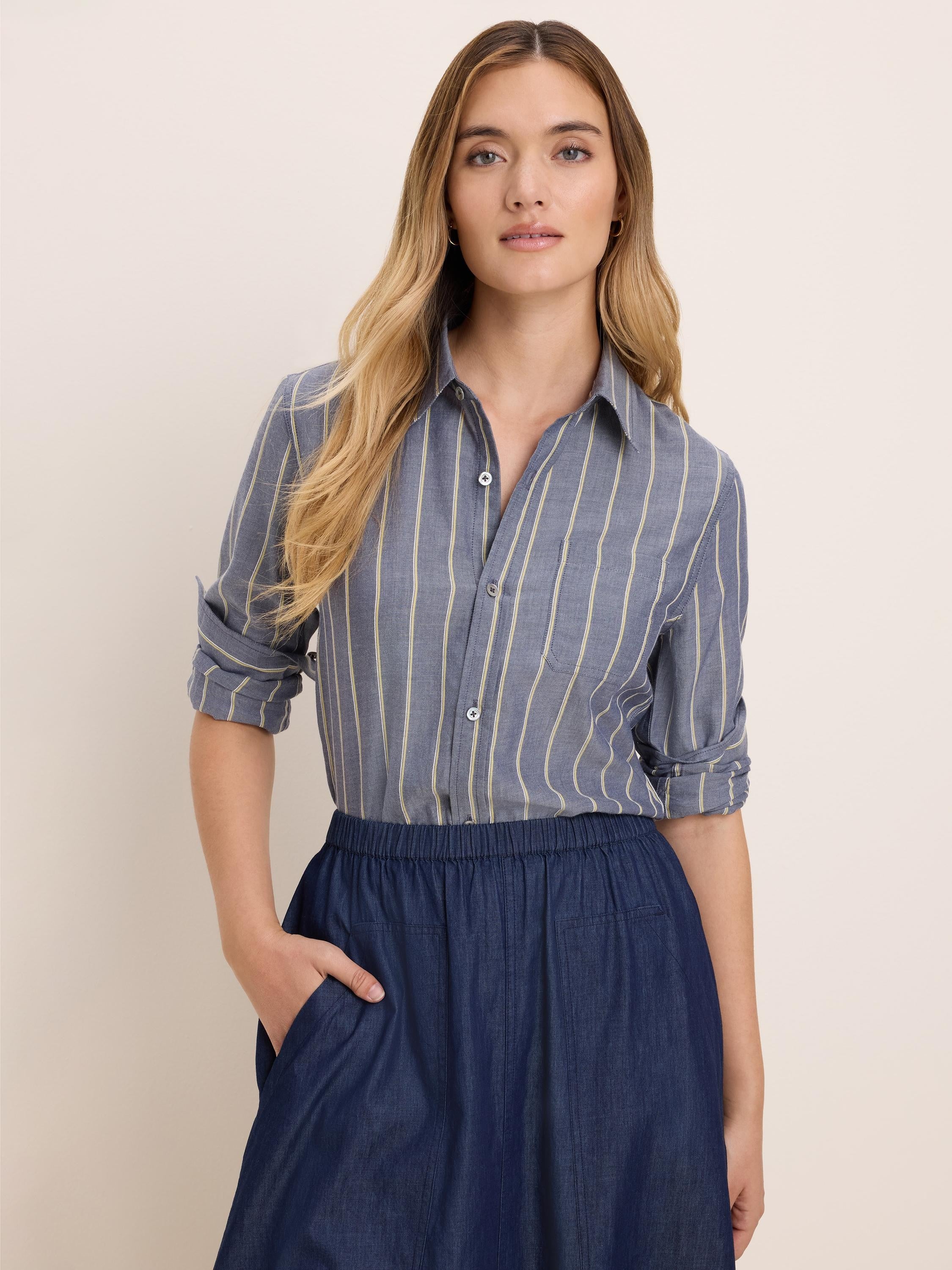 Blue dobby stripe shirt with light yellow vertical stripes, button-down front, chest pocket, and rolled sleeves.
