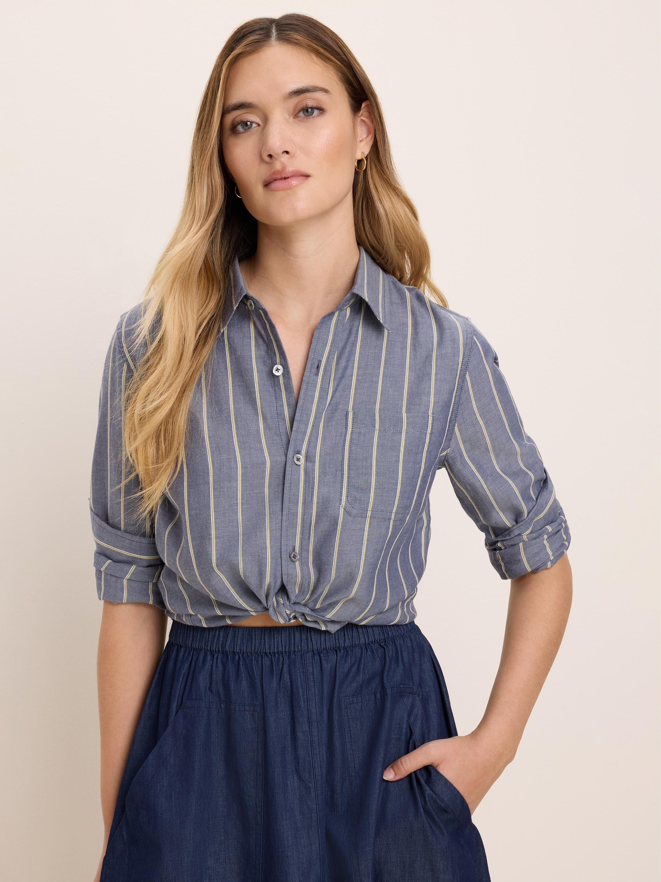 Dobby Stripe Shirt: Blue fabric with pale yellow vertical stripes, rolled sleeves, and a tied front.