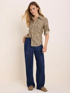 Tan shirt with dark brown cheetah spots. Button-up, collared, with rolled sleeves.