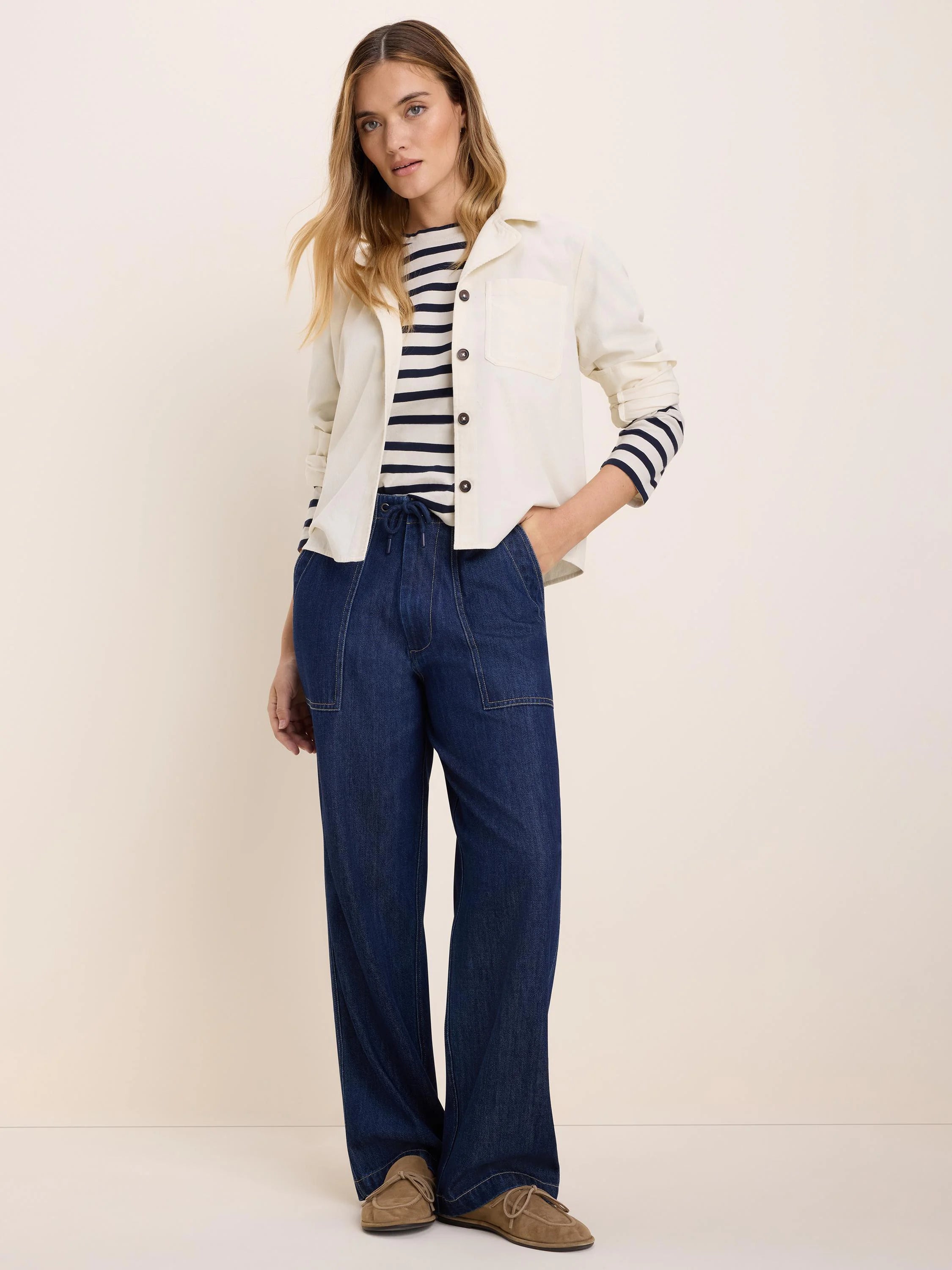 Cream baby cord shirt jacket with a collar, dark front buttons, and chest patch pockets.