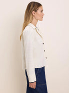 Off-white baby corduroy shirt jacket with a collar, dark buttons, and cuffed long sleeves.