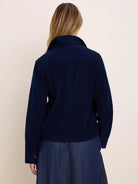 Navy blue fine corduroy shirt jacket, back view. Features a collar, long sleeves with button cuffs, and a back yoke.