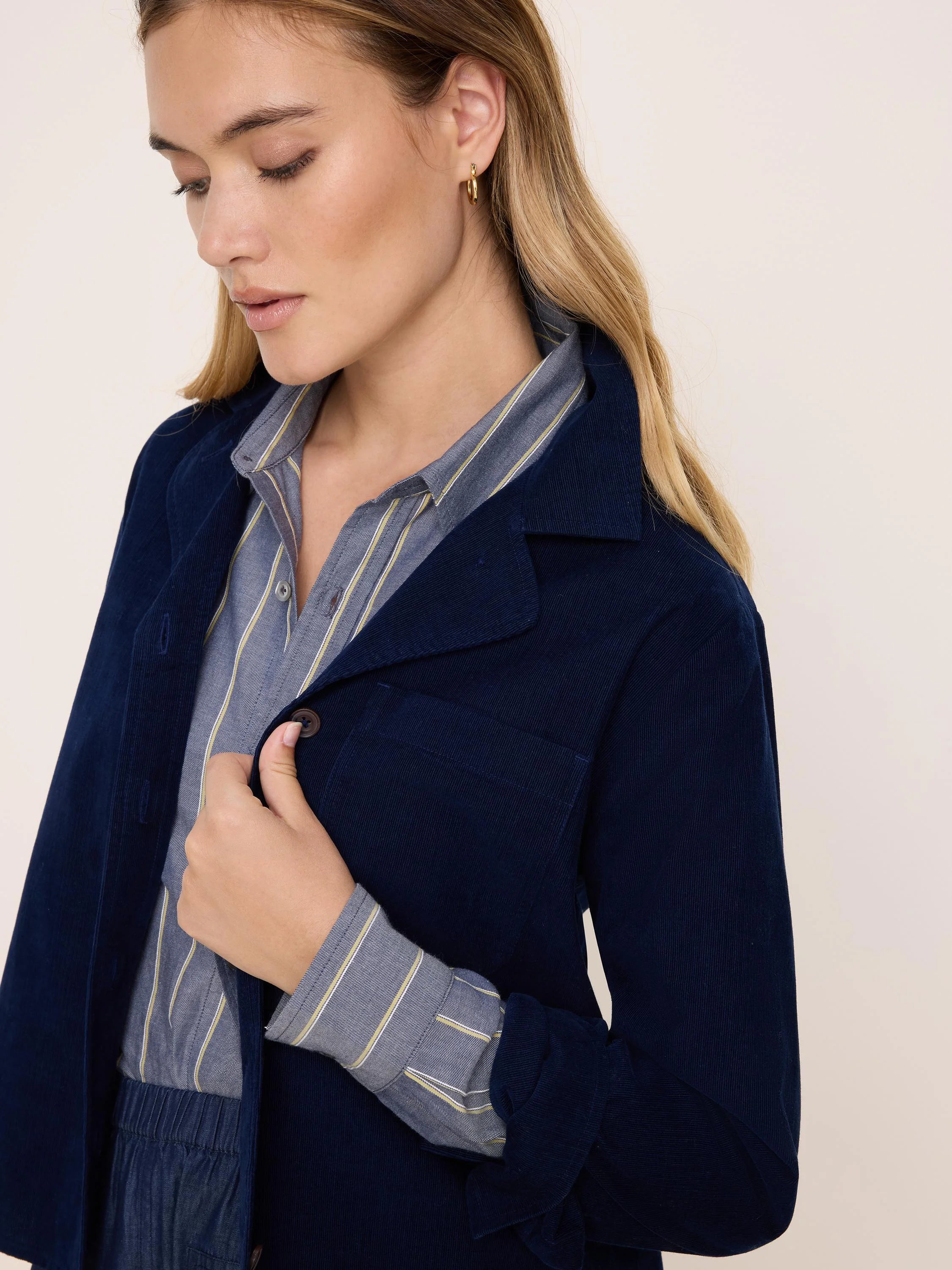 Navy blue corduroy shirt jacket with fine-rib texture, buttons, and a chest pocket.
