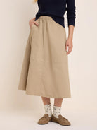 Khaki twill cargo skirt with elastic waist, midi-length, and large front patch pockets.