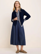 Drapey dark blue denim midi skirt with an elastic waist and large patch pockets.