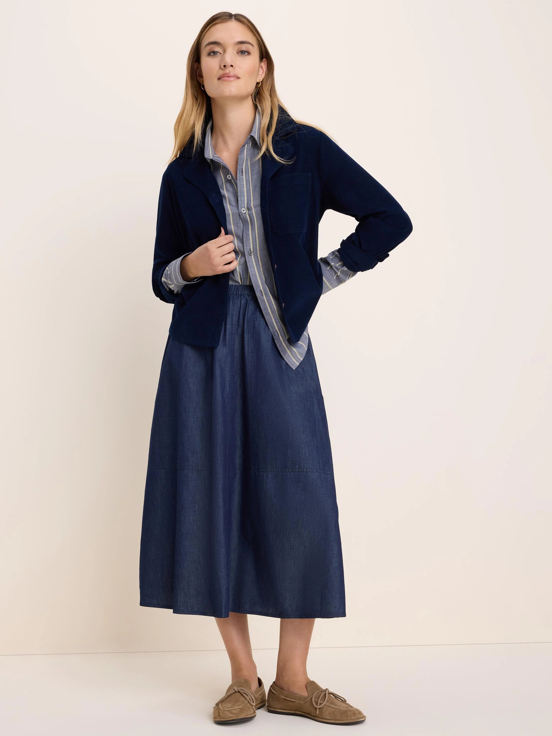 Drapey dark blue denim midi skirt with an elastic waist and large patch pockets.