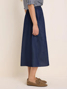 Indigo drapey denim skirt, A-line midi, elastic waist, and a side patch pocket.