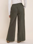 Dark olive green baby cord wide-leg pants with an elasticated waist, shown from the back.