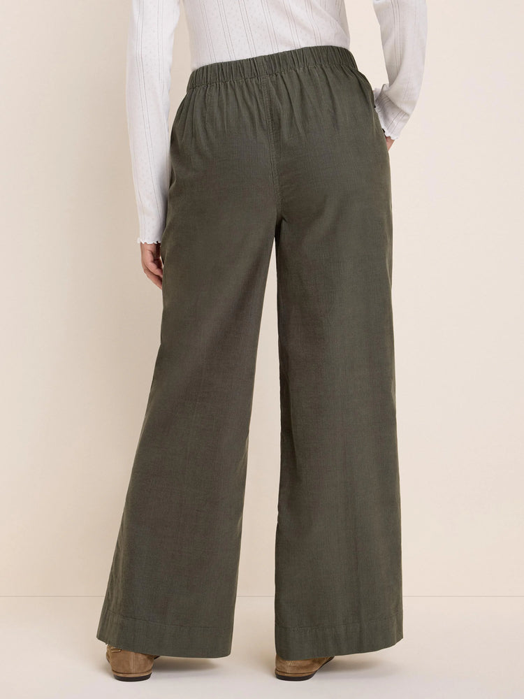 Dark olive green baby cord wide-leg pants with an elasticated waist, shown from the back.