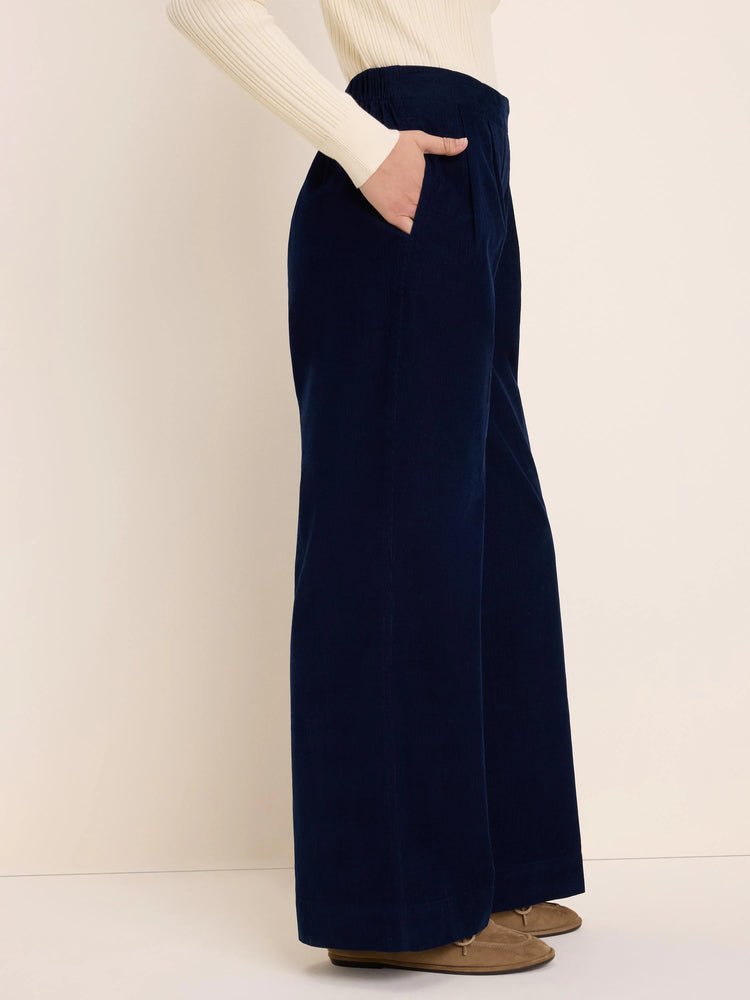 Navy baby corduroy wide-leg pants with a gathered waist and a side pocket, worn by a model.
