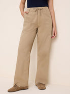 Khaki twill pants with drawstring waist, wide legs, and large front pockets.