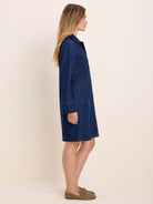 Dark blue denim collared shirt dress with long sleeves, front buttons, and chest pockets. Falls above the knee.