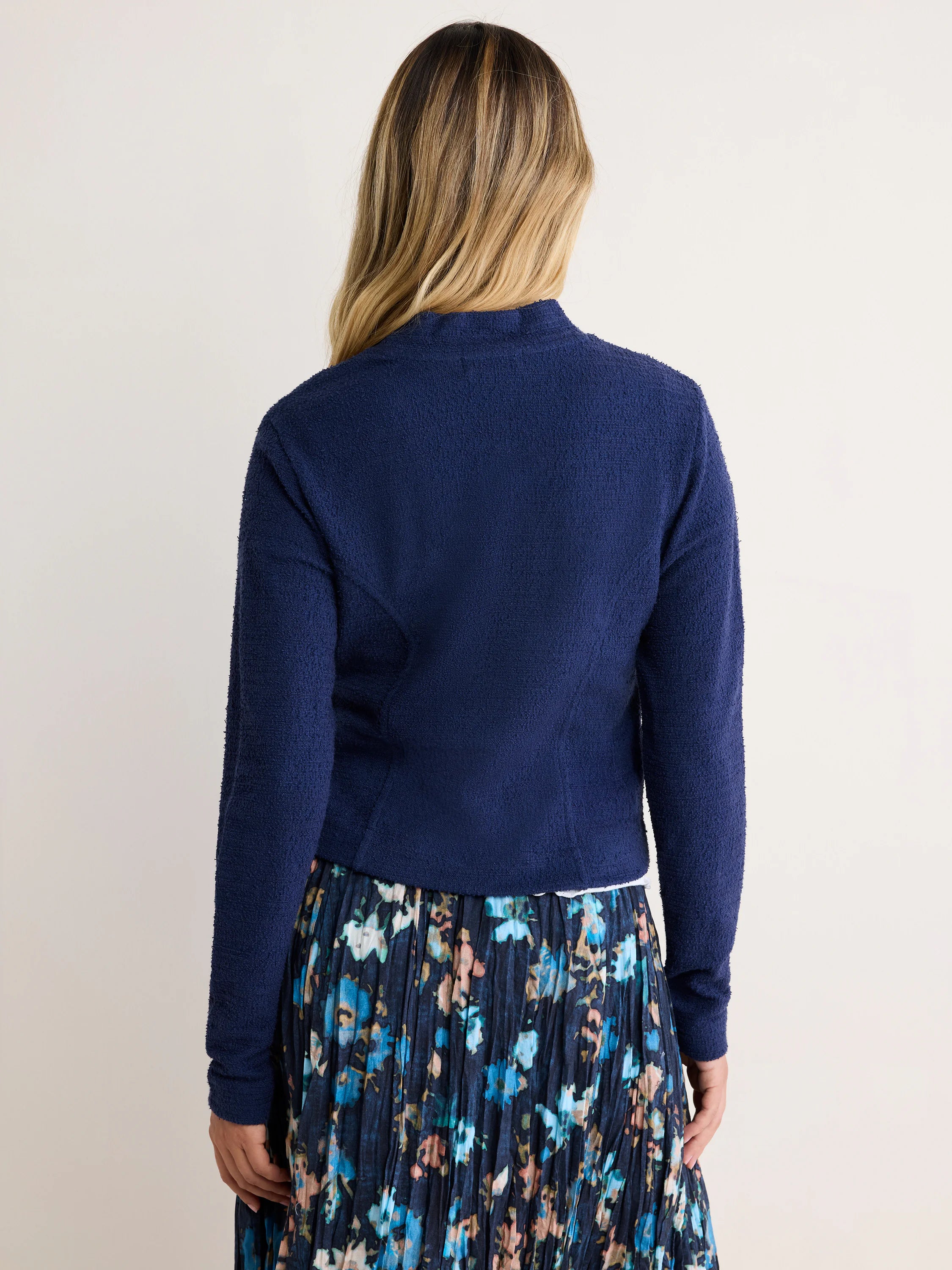 Navy textured knit bomber jacket, seen from the back. Cropped fit with a stand collar.