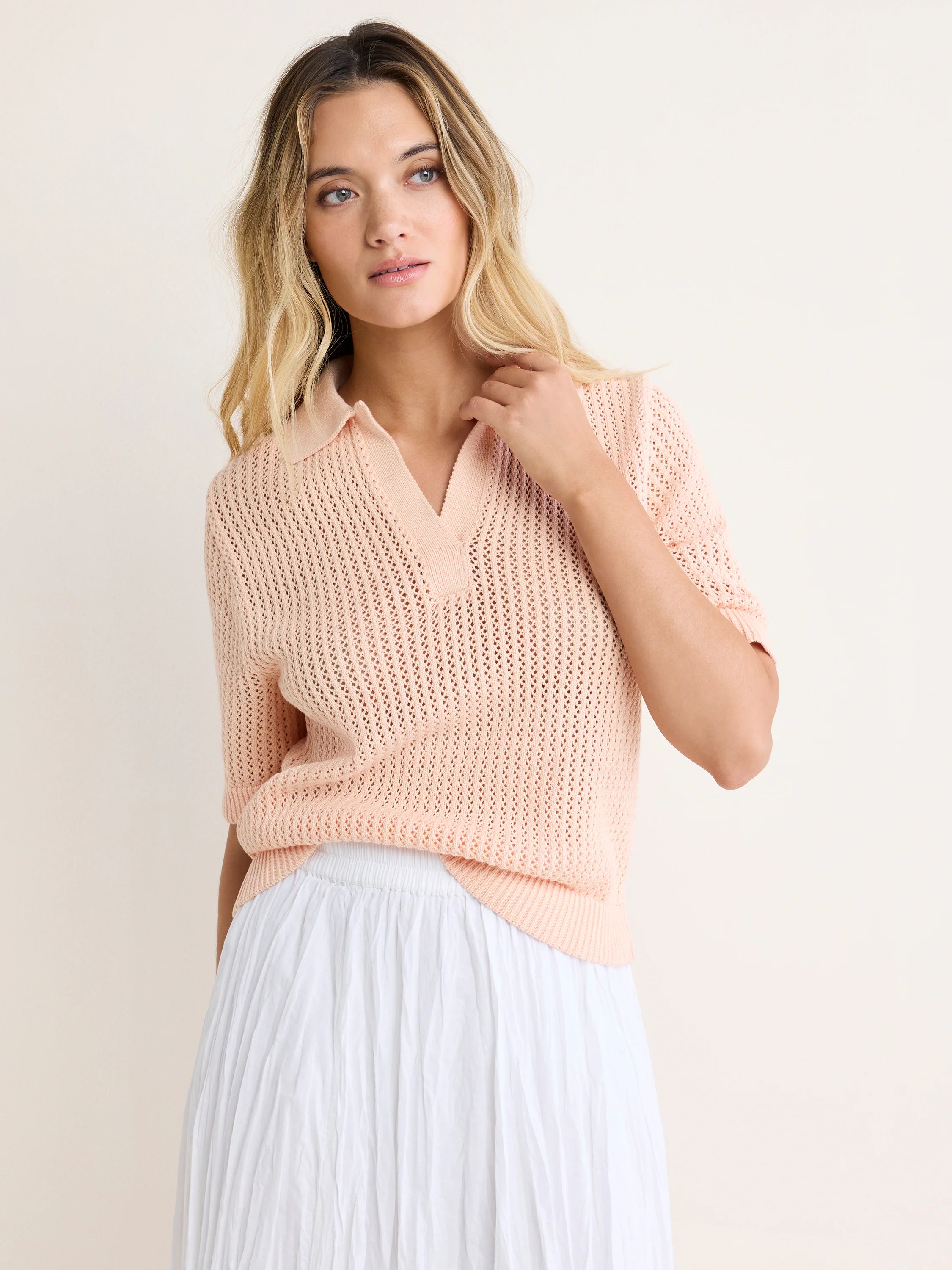 Light peach mesh polo sweater with a collared V-neck, short sleeves, and visible open knit design.