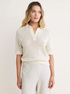 Off-white mesh polo sweater with collar, V-neck, short sleeves, and ribbed cuffs/hem.