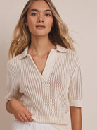 Off-white mesh polo sweater with open V-neck collar, short sleeves, and ribbed details.