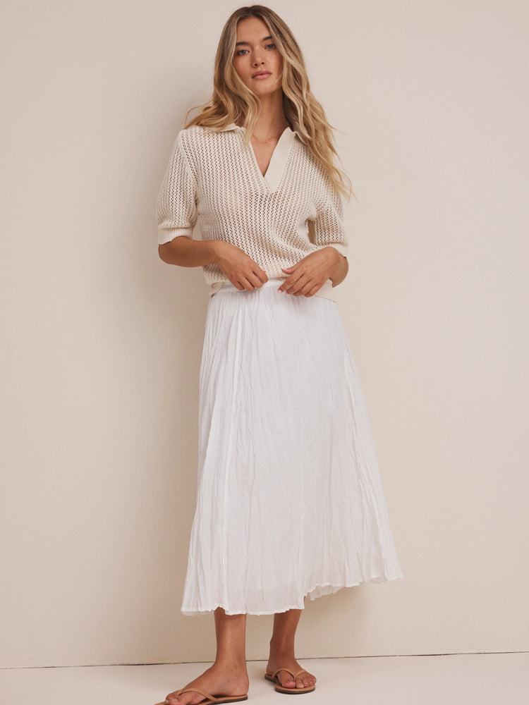 Off-white open-knit polo sweater with a pointed collar, V-neck, and short sleeves.