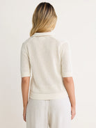 Off-white mesh polo sweater with short sleeves, ribbed collar, cuffs, and hem. Model shown from the back.