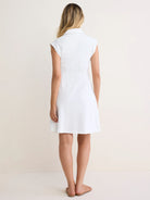 White collared dress, sleeveless, fitted bodice with vertical back pleats, flared above-knee skirt.