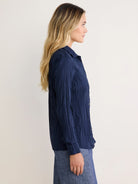 Navy blue long-sleeve button-up shirt with a distinct crinkled texture, shown in profile.