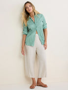 Mint green crinkled cotton button-up shirt with rolled sleeves.