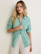 Muted green crinkled shirt with collar, rolled sleeves, and silver snap buttons.