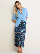 Light blue crinkled button-down shirt with long sleeves rolled up to the elbows.