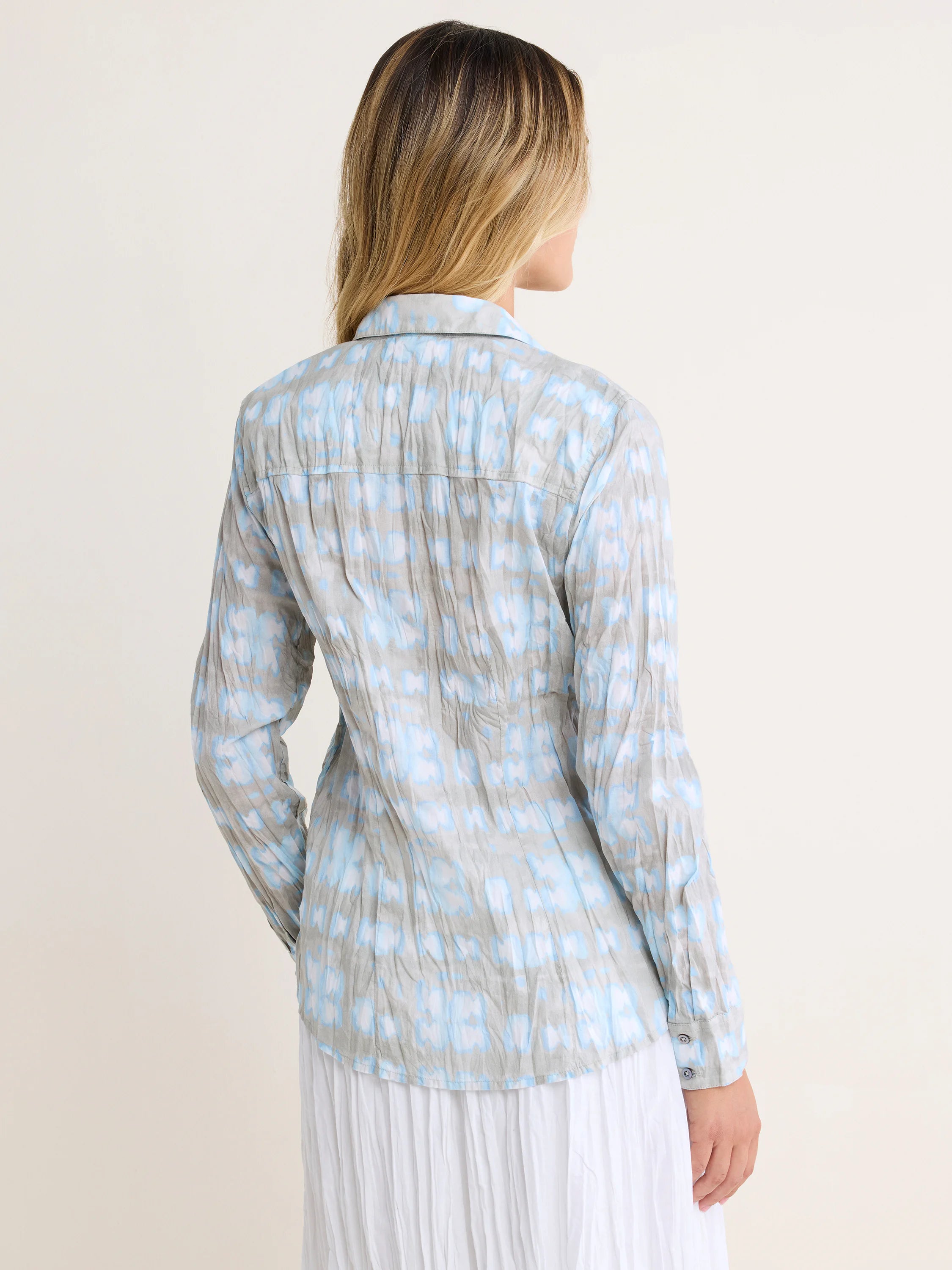 Crinkled grey shirt with irregular light blue and white shibori pattern, seen from back.