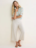Light blue and beige collared cotton shirt with shadow floral pattern, sleeves rolled.
