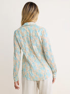 Long-sleeve crinkled shirt, light tan with pale blue abstract floral pattern.