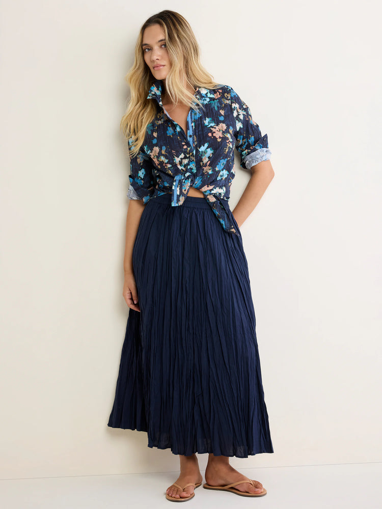 Navy cotton button-up shirt with blue/peach floral print, tied at waist, rolled sleeves. Features a crinkled texture.