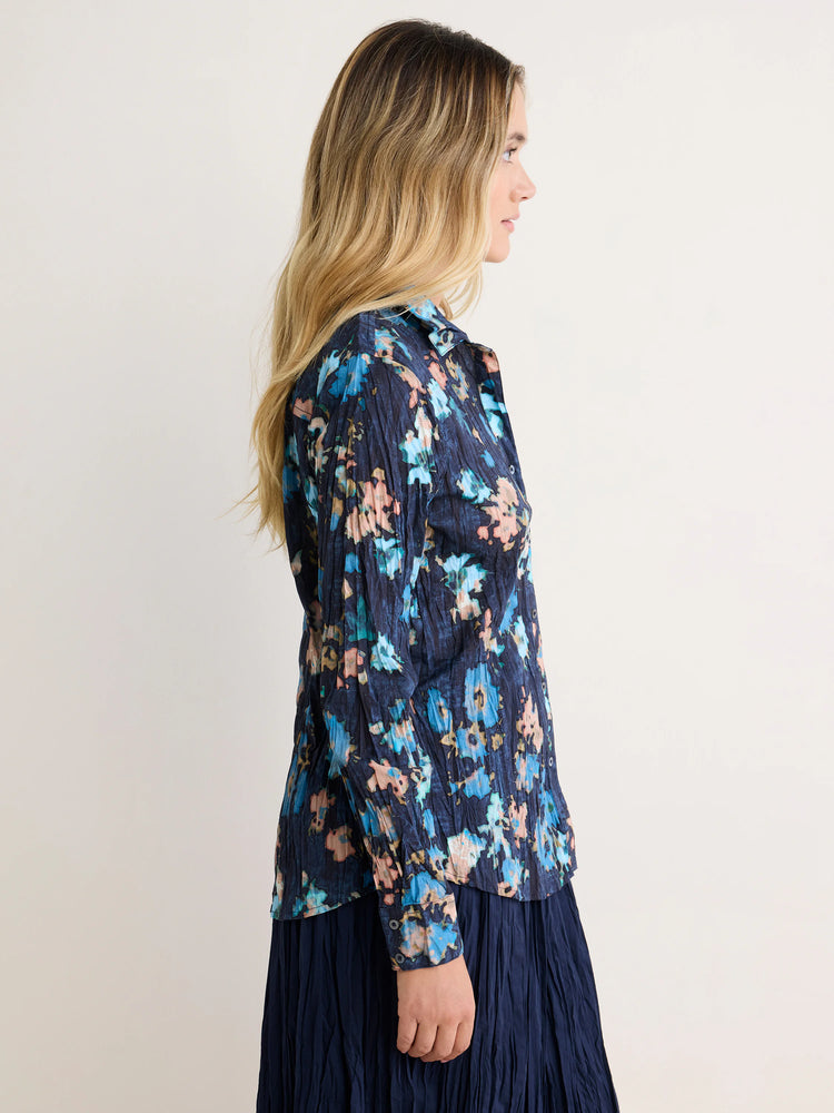 Dark blue crinkled shirt with abstract light blue, teal, and peach floral print.