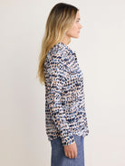 Long-sleeve cotton shirt with a pattern of dark blue, light blue, and peach irregular spots on white.