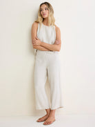 Sleeveless light oatmeal linen blend tank with a round neck, modeled.